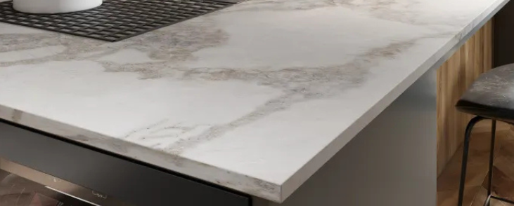 Modern kitchen with marble countertop and stools.